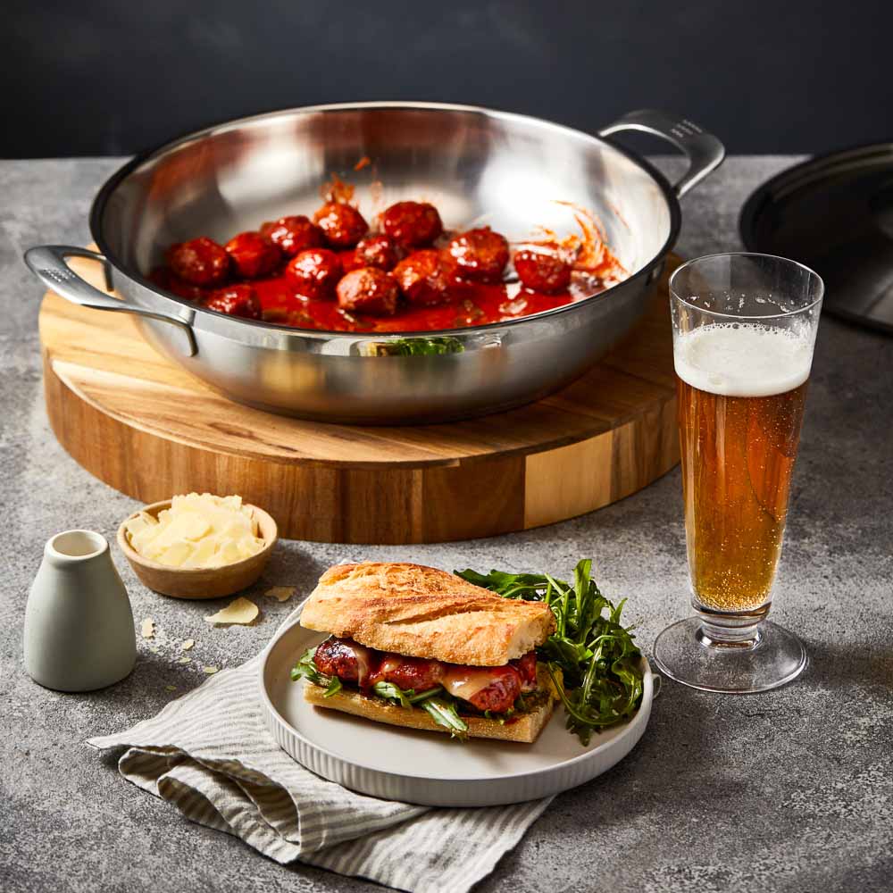 Meal setting with meatball sandwich beer and greens grey cookware 32cm saute pan with lid - Baccarat