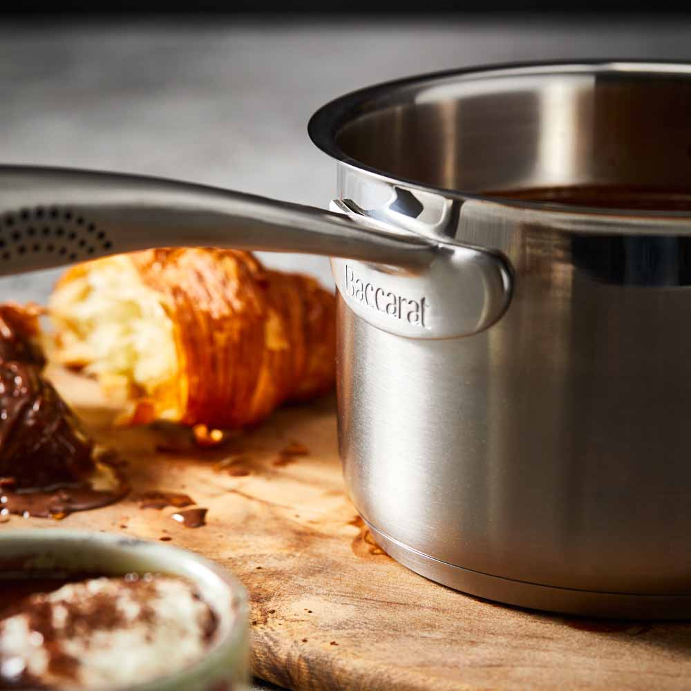 A stainless steel pot with a lid on wooden surface silver cookware 16cm saucepan with lid - Baccarat
