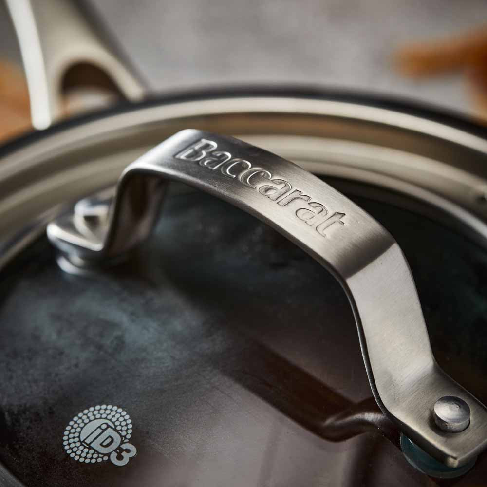A stainless steel pot with a lid on wooden surface silver cookware 16cm saucepan with lid - Baccarat