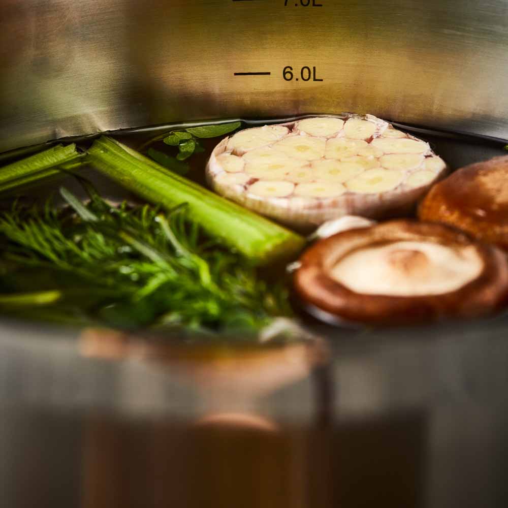 Close-up of a stainless steel pot lid with a handle and steam holes modern cookware 24cm - Baccarat