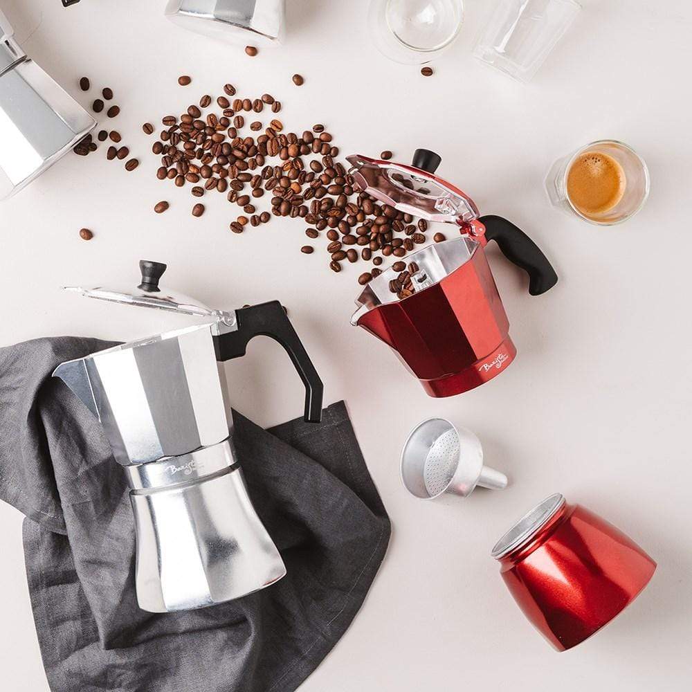 Coffee beans spilling from a red espresso maker on a white surface - Baccarat barista italico