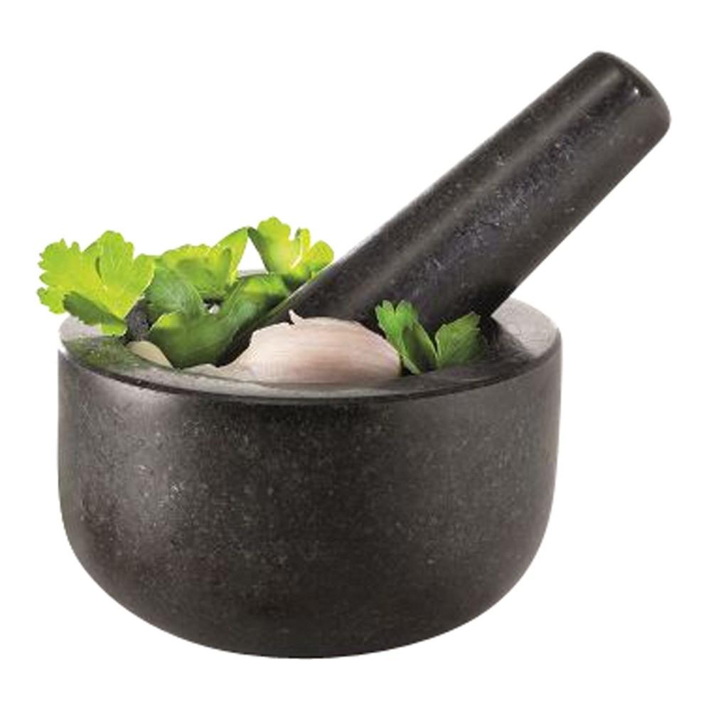 Top view of a dark gray mortar and pestle with fresh herbs and nuts - Baccarat spice market gino