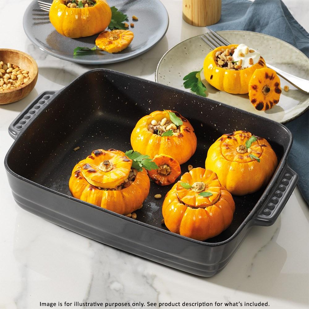 Four roasted stuffed pumpkins in a rectangular baking dish garnished with herbs - Baccarat stone
