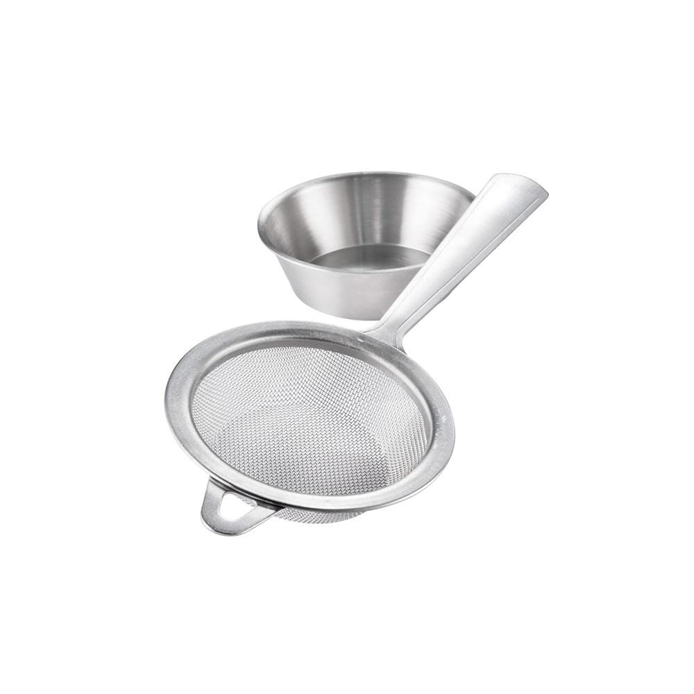 A stainless steel tea strainer with a handle beside a stylish bowl - Baccarat tea house