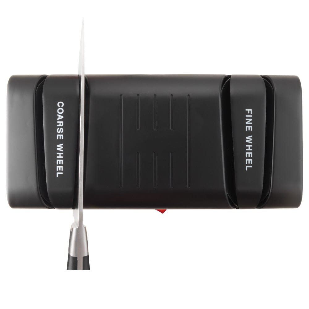 Electric knife sharpener on kitchen counter next to sliced mangoes black knife sharpener - Baccarat