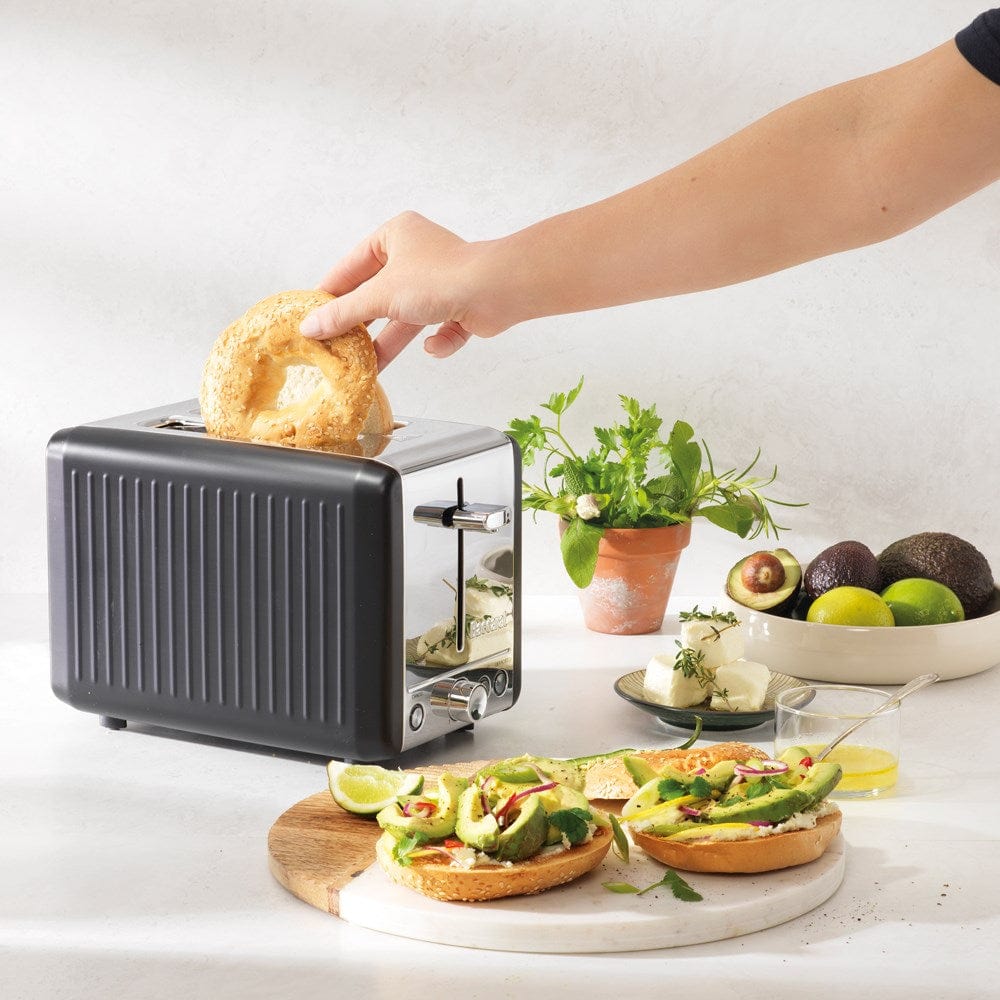 sleek black toaster surrounded by fresh bread and vibrant green avocados - Baccarat the toasty slice
