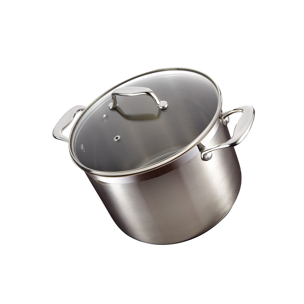 A silver stockpot with lid surrounded by kitchen utensils on a gray background - Baccarat