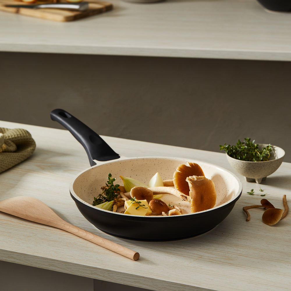 A frying pan with cooked mushrooms on a kitchen counter black handle - Baccarat ceramix fry pan 24cm