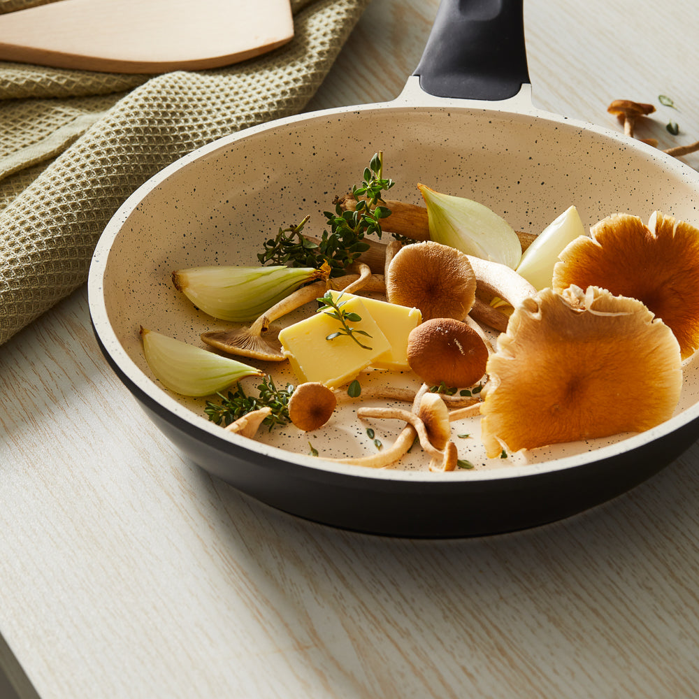 A frying pan with cooked mushrooms on a kitchen counter black handle - Baccarat ceramix fry pan 24cm
