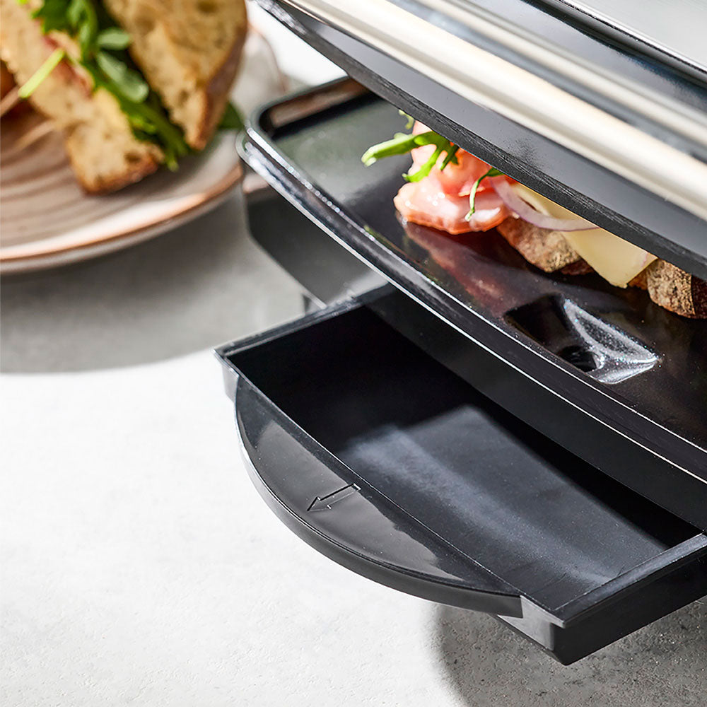 A close-up shows the drip tray being pulled out from the base of the press.
