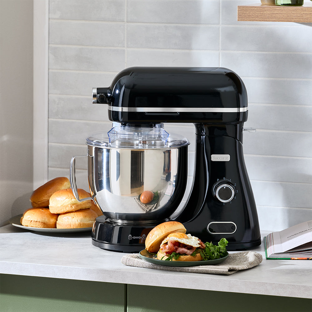 Black stand mixer on a kitchen counter with sandwiches and buns.