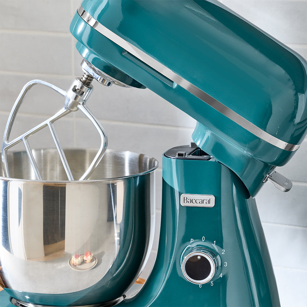 Turquoise stand mixer with a silver mixing bowl on a white background