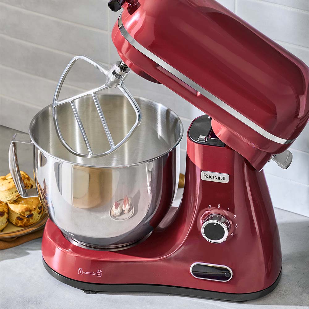 Red stand mixer with a silver bowl on a kitchen counter.