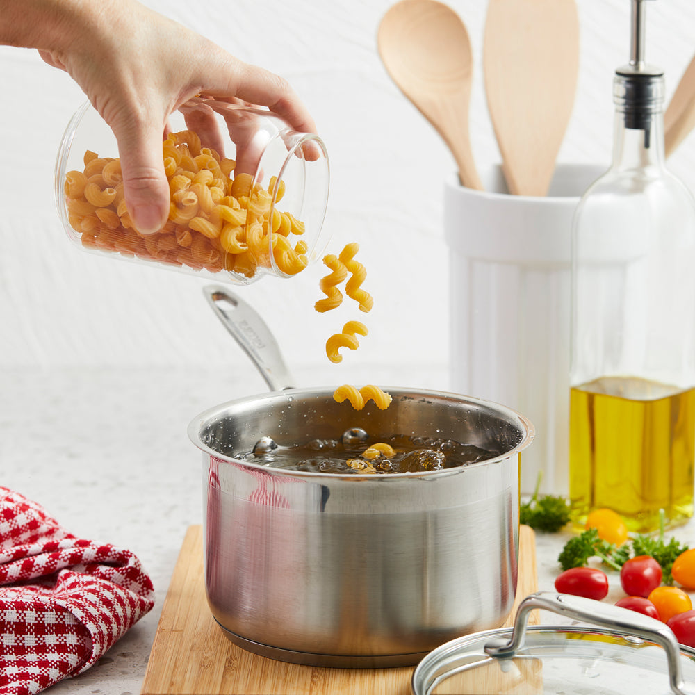 A pot on the stove filled with pasta and utensils nearby silver saucepan with lid 16cm - Baccarat