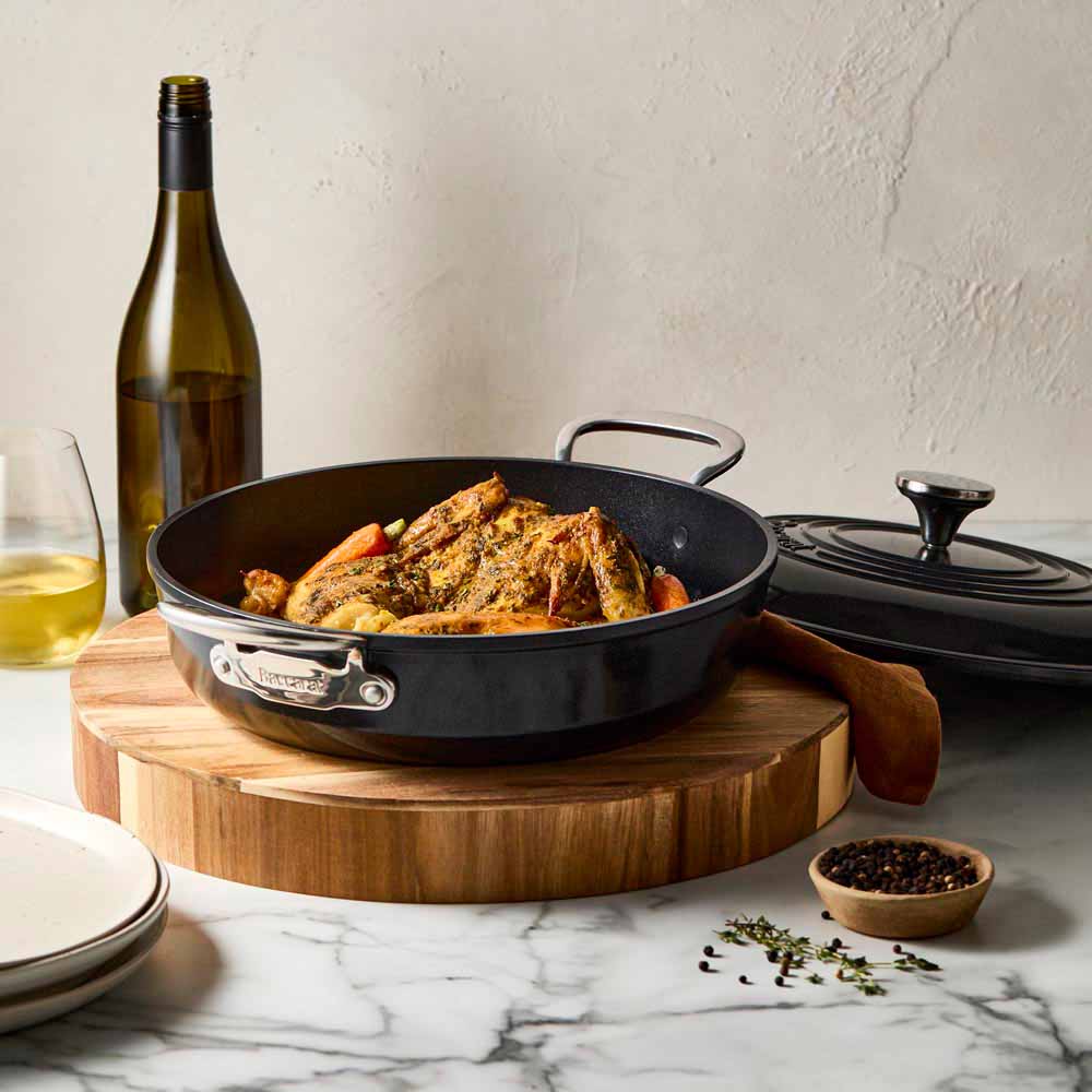 Roasted chicken with vegetables in a black frypan on a wooden board black frypan 28cm - Baccarat