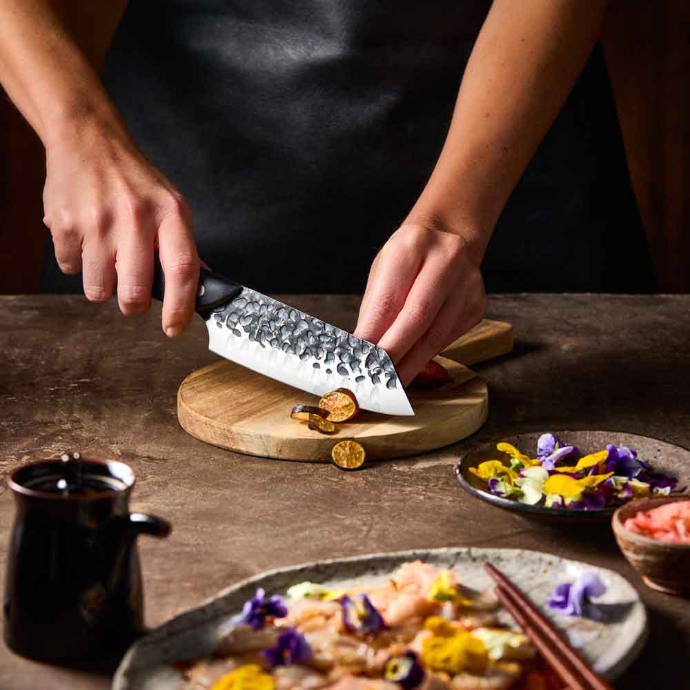 Woman slicing eggplant with Baccarat KUROI KIBA Santoku Knife 14cm at Baccarat