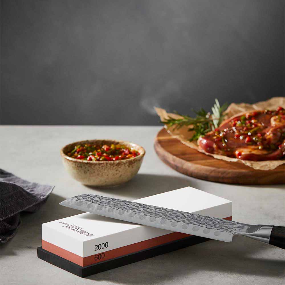 Knife sitting on top of a whetstone 600/2000 - Baccarat