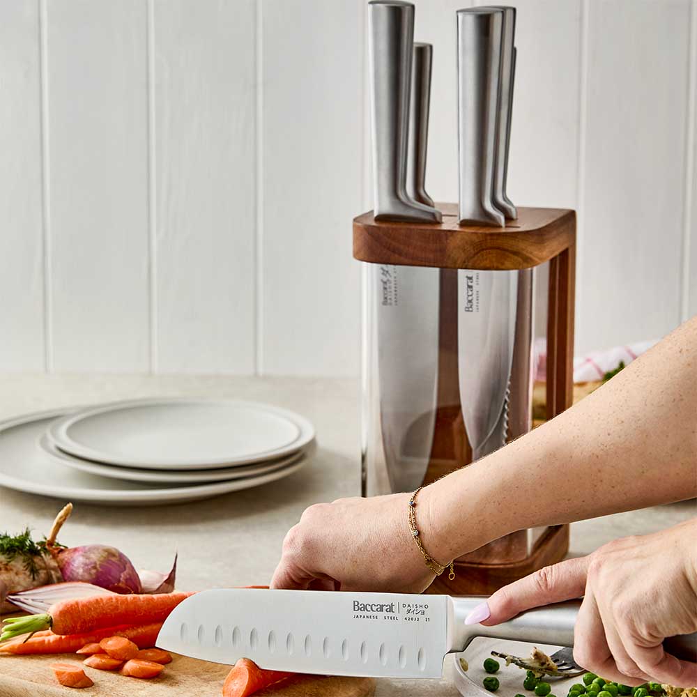 woman chopping a carrot with a japanese steel santoku knife